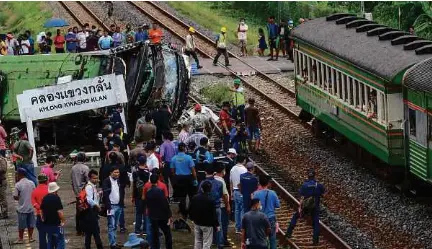  ?? (Foto AFP) ?? Sekurang-kurangnya 20 penumpang terbunuh dalam insiden pertembung­an antara sebuah bas dan kereta api di Thailand, semalam.