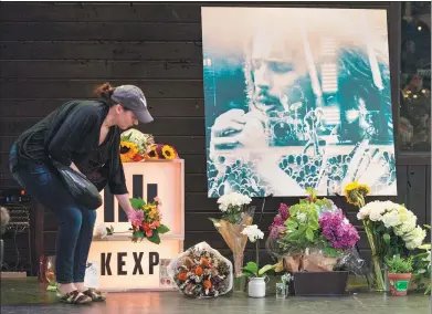  ?? DAVID RYDER / AGENCE FRANCE-PRESSE ?? A woman leaves flowers on stage during a memorial for singer Chris Cornell, the former frontman of Soundgarde­n, at the KEXP radio studio on Thursday in Seattle, Washington. Cornell, 52, was found dead in Detroit on Wednesday.