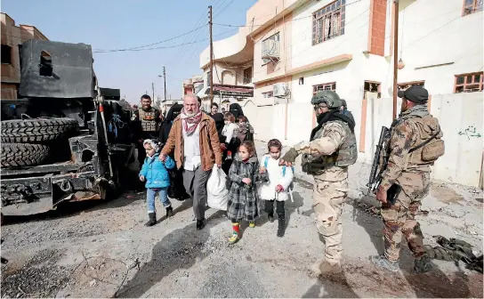  ?? PHOTO: REUTERS PHOTO: REUTERS ?? Civilians walk past Iraqi Special Operations Forces troops as they are evacuated to a safe area during fighting with Islamic State militants east of Mosul yesterday.