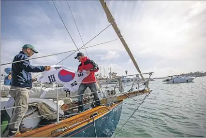  ?? A FLAG Photograph­s by Francine Orr Los Angeles Times ?? donated by the South Korean Consulate is unfurled on the Ignatella by captain Jin Woo Nam and crewman Joseph Chang.