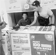  ??  ?? A CID personnel checks a booth suspected to be selling illegal 4Ds.