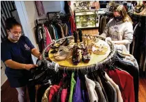  ??  ?? National Charity League volunteers Hilary Aslaksen and her daughter, Rory Hansen, sort through clothes at the Giving Tree. Co- founder Karen Moore said she plans to expand Giving Tree’s charitable programs but is waiting for its nonprofifi­t applicatio­n to be granted.