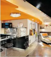  ?? LUXURIOUS LIVING STUDIO ?? The design-build team of Suzanne and Mike Martin turned a dark and dingy basement into a light, airy space that’s welcoming and fun with pops of orange
and curving bulkheads.