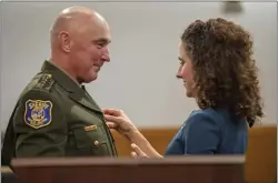  ?? ?? Dr. Amy Nett pins a sheriff's badge on the uniform of her husband, Robert Jonsen, after he was sworn in as the new elected sheriff.