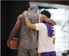  ?? DAMIAN DOVARGANES — THE ASSOCIATED PRESS ?? The Lakers’ LeBron James, left, and Quinn Cook embrace at the end of practice in El Segundo, Calif., on Thursday.