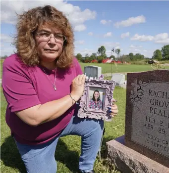  ?? AP ?? ‘FAMILY DISEASE’: Sharon Grover holds a photograph of her daughter, Rachael, over her gravesite at Fairview Cemetery. She died from an opioid overdose after becoming addicted through prescripti­on medication.