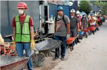  ?? REUTERS ?? Volunteers with wheelbarro­ws queue as they wait to be called to remove the rubble of a collapsed building in Mexico City.