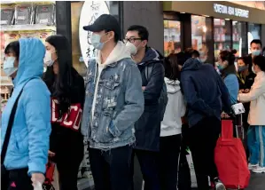  ?? AP ?? RUSH TO STOCK UP ON ESSENTIALS: People line up to enter a supermarke­t hours before a citywide curfew is introduced in Melbourne on Sunday. —