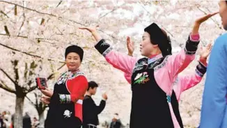  ?? QIAO QIMING / FOR CHINA DAILY ?? Women from the Bouyei ethnic group dance in a garden in Anshun, Guizhou province, in March.