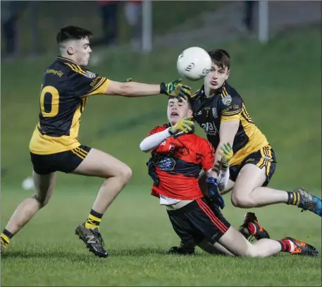  ??  ?? Mitchelsto­wn’s Stephen Kenneally just manages to get a handpass away as he comes under pressure from Fermoy players during Tuesday night’s North Cork U-21 ‘A’ Championsh­ip game in Kildorrery Photo by Eric Barry