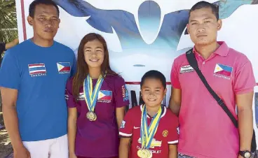  ??  ?? Kyla Soguilon of Aklan and Marc Bryan Dula of the Susan Papa Swim Academy pose with coaches Manny de Leon and Marlon Dula. Soguilon and Dula broke the Philippine swimming records during the 74th PSL leg series dubbed Capiztahan 2015 in Roxas City.