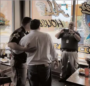  ?? Mike DeBonis/The Washington Post ?? Sen. Joe Donnelly, D-Ind., second from left, poses for a photograph with a supporter at Savage's Ale House in Muncie, Ind. More than a year before the vote, his re-election bid is rated a toss-up.