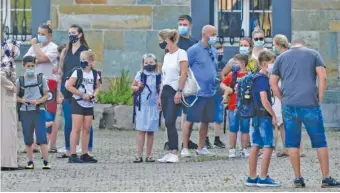  ?? AP PHOTO/MARTIN MEISSNER, ?? Parents wait with children on the schoolyard for the start of their first day at a school Aug. 12 in Gelsenkirc­hen, Germany.