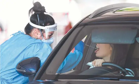  ?? ?? A health worker swabs a woman at a Covid-19 testing clinic in Brisbane. Picture: NCA NewsWire/Dan Peled