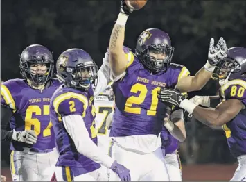  ?? Photos by Jenn march / Special to the times union ?? troy football players congratula­te, Kiernan Gilbert (21) after recovering an Averill Park fumble during a game on friday in troy. the flying Horses won 24-12 to clinch the Capital division title.