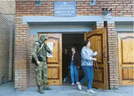  ?? AP ?? A Russian serviceman guards the entrance to a polling station during suspect local elections Sunday in Donetsk, the capital of Russian-controlled Donetsk region, eastern Ukraine.