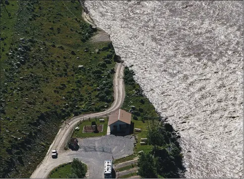  ?? (AP/David Goldman) ?? A road ends Thursday where floodwater­s washed away a house in Gardiner, Mont.