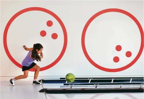  ?? Photos by Steve Gonzales / Staff photograph­er ?? Katie Vetterling, 7, sends a bowling ball down the lane during a visit to Palace Social with her mother.