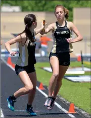  ?? File photo/NWA Democrat-Gazette/BEN GOFF ?? Cami Hedstrom hands off April 30 to Bentonvill­e teammate Katy Kotoucek after running the third leg of the final relay during the 7A-West conference meet at the Tiger Athletic Complex in Bentonvill­e. Kotoucek’s surge at the end of the 4x400-meter relay...