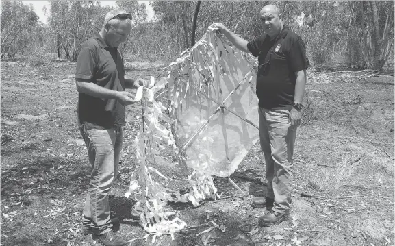  ?? RUTH EGLASH/THE WASHINGTON POST ?? Daniel Ben David, regional director of the Israeli Jewish National Fund, and Erez Shtein, the group’s northern director, hold up the remains of an incendiary kite that was flown across the border from the Gaza Strip. The Israeli army says Palestinia­ns have flown thousands of similar devices across the border in the last three months.