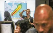  ?? JOHN SPINK / JSPINK@AJC.COM ?? Natalie Aviles (center), U.S. Department of Health and Human Services informatio­n management specialist, interacts with colleagues Wednesday at the FEMA Region 4 Regional Response Center in DeKalb County as Hurricane Dorian neared Georgia.