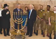  ?? (GPO) ?? PRIME MINISTER Benjamin Netanyahu and US Ambassador David Friedman light the menorah at the Western Wall, as Western Wall Rabbi Shmuel Rabinowitz and the ambassador’s wife, Tammy, look on.