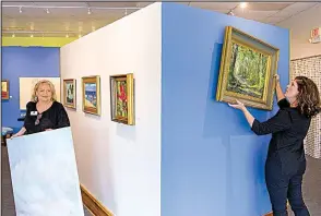  ?? Arkansas Democrat-Gazette/BENJAMIN KRAIN ?? Art on the Green gallery director Brenda McClain (left) and curator of education Kelly Booy set up an exhibit Thursday in Conway.