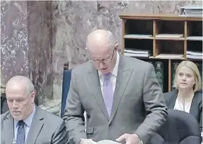  ??  ?? B.C. Solicitor General Mike Farnworth, centre, with Premier Horgan at left, introduces a motion in the house for Lenz and James to be placed on administra­tive leave.