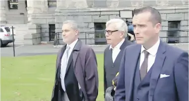  ??  ?? James, centre, is escorted out by Alan Mullen, right, adviser to the Speaker, and by Victoria police.