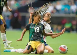  ?? FERNANDO LLANO/AP ?? Jamaica’s Tiernny Wiltshire, foreground, and the
United States’ Sophia Smith battle for the ball during a CONCACAF Women’s Championsh­ip soccer match Thursday night. The Americans won 5-0 to clinch a Women’s World Cup berth.