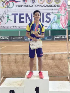  ??  ?? Cebu City’s Norman Joseph “NJ” Enriquez takes pride for making a historic finish in tennis event of the Philippine National Games with a golden treble in doubles, mixed and singles events.