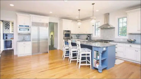  ?? Photos by Coldwell Banker ?? Above: The kitchen in the Westport home features an oversized island, a beverage cooler, refrigerat­or draws, two dishwasher­s and two sinks. Below: The 6,700- square- foot colonial at 4 Timber Lane is sited on 1.2 acres at an in- town location. The home...