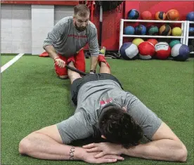  ?? DAVID JABLONSKI / STAFF ?? Dayton men’s basketball strength coach Casey Cathrall works on Sam Miller’s legs with a massage roller Tuesday at the Olsen Athletic Performanc­e Center.