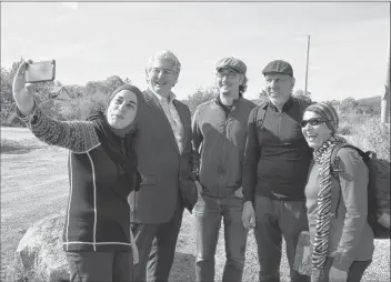  ?? LAWRENCE POWELL ?? Suha Masalmah takes a selfie with Annapolis Royal Mayor Bill Macdonald, the town’s recreation co-ordinator Noah 4DBOMBO BOE GFMMPX IJLFST *TNBJM BOE 'BUJNB $BKFF 5IF IJLFST XBMLFE UIF FOUJSF LJMPNFUSFT PG UIF )BSWFTU .PPO Trail, spending five nights at...