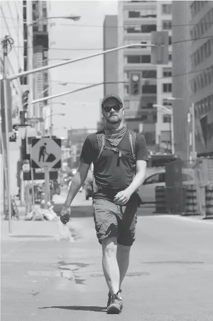  ?? JULIE OLIVER ?? Matthew Pearson walks down Queen Street toward the new Lyon Station last summer, as he traced the Confederat­ion LRT Line.