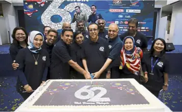  ?? — Bernama ?? One for the album: Ameer (third from right) with Mydin Mohamed Holdings Bhd executive director Murad Ali Mydin (centre) cutting a cake with staff in conjunctio­n with the company’s 62nd anniversar­y.