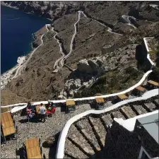  ?? JANET PODOLAK — FOR THE-NEWS-HERALD ?? Those tasting Santorini’s Assyrtiko wines at Venetsanos Winery have a view of a twisty road leading to the shore.