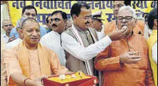  ??  ?? UP chief minister Yogi Adityanath distribute­s sweets after taking oath as member of the state legislativ­e council in Lucknow on Monday along with four ministeria­l colleagues. Deputy chief minister Keshav Prasad Maurya, who also took the oath, is seen...