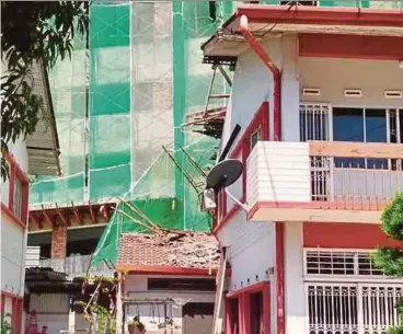  ?? PIC BY MUHAMMAD ZUHAIRI ZUBER ?? A Bangladesh­i landed on the roof of this house in Melaka yesterday after falling from the20th floor of a building under constructi­on.