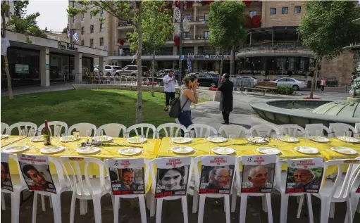  ?? (Chaim Goldberg/Flash90) ?? A SEDER table in Jerusalem displays pictures of Israelis held hostage by Hamas terrorists, on the eve of Passover.