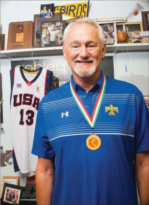  ?? WILLIAM HARVEY/RIVER VALLEY & OZARK EDITION ?? Guy-Perkins basketball coach John Hutchcraft stands in his office in the school gymnasium. He wears the gold medal he won while playing for Team USA 60s in the 14th Federation of Internatio­nal Masters Basketball Associatio­n World Maxibasket­ball...