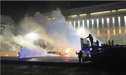  ?? Photograph: Vladimir Tretyakov/AP ?? Riot police move on protesters in Almaty, Kazakhstan, 5 January 2022. The protests had started because of unreliable power supplies caused by crypto miners in their country.