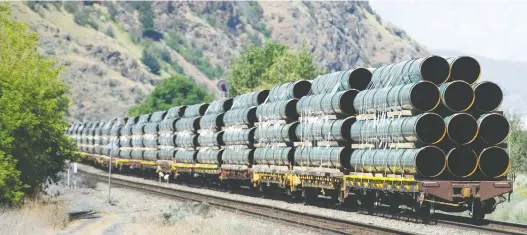  ?? GERRY KAHRMANN/POSTMEDIA NEWS FILES ?? Pipes for the Trans Mountain pipeline expansion project, also known as TMX, are transporte­d by rail through Kamloops, B.C., in June. The Liberal government says it wants to eventually sell TMX back to the private sector and use the funds for clean energy developmen­t and other climate change action projects.