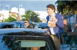  ??  ?? Trudeau leaves the store with take-out.