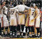  ?? WILFREDO LEE/THE ASSOCIATED PRESS ?? Miami Heat players celebrate Monday after defeating the Cleveland Cavaliers 124-121 in overtime in Miami.