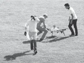  ??  ?? Dr. Tim Amukele walks away after handing off a package Wednesday as a drone delivery service conducted test flights to determine whether drones can be used to carry human medical samples during major storms, earthquake­s or other disasters.