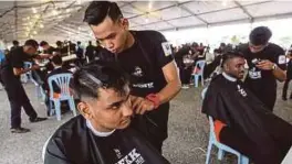  ??  ?? Gabungan institusi pusat latihan dan kemahiran awam dan swasta negara mencipta rekod gunting rambut paling ramai di Malaysia.