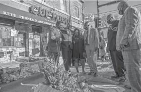  ?? KEREM YUCEL/AFP VIA GETTY IMAGES ?? George Floyd’s family and family lawyer Ben Crump, right, make a March 12 visit to a memorial at the site where Floyd died.