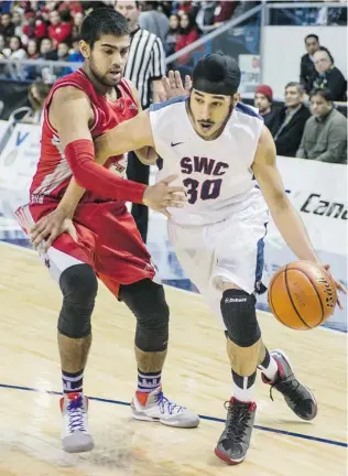  ?? STEVE BOSCH/ PNG ?? Sir Winston Churchill Bulldog Gary Minhas drives past the Holy Cross Crusaders’ Brandon Pereira at the B. C. high school senior boys’ 4A championsh­ip game Saturday at the Langley Events Centre. Minhas’ brother Mindy was named tournament MVP.