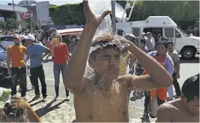  ??  ?? UN BAÑO RÁPIDO. UN JOVEN QUE VIAJA EN LA CARAVANA MIGRANTE TOMÓ AGUA DE UN HIDRANTE PÚBLICO EN TAPACHULA PARA DARSE UN BAÑO.